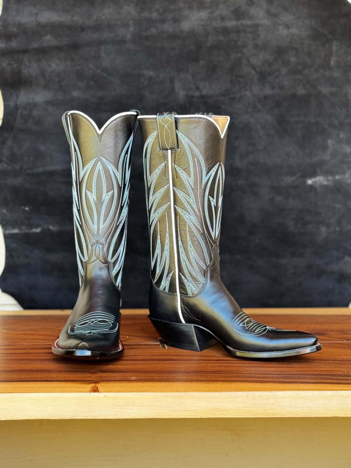 Olive green boot tops with pale stitching over black vamps and a cutter toe