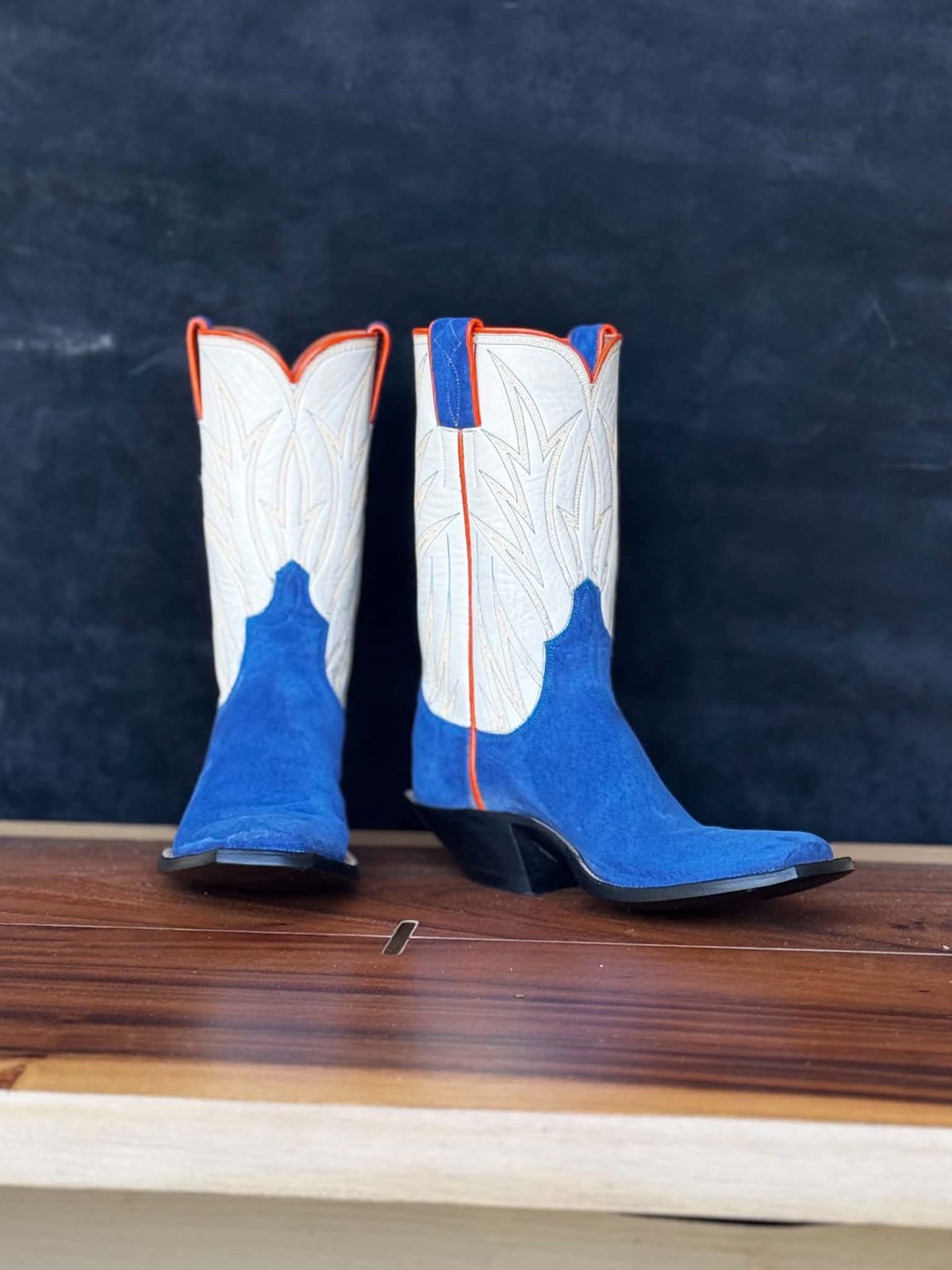 White boot tops with orange piping over royal blue suede vamps